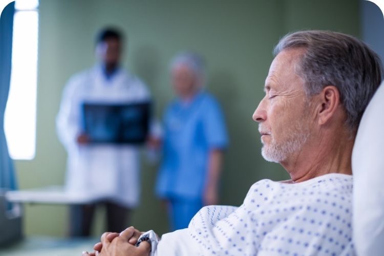 A male hospital patient lying in a bed.