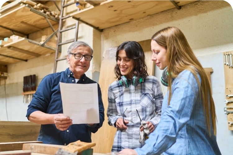 A happy boss talking with two happy employees.