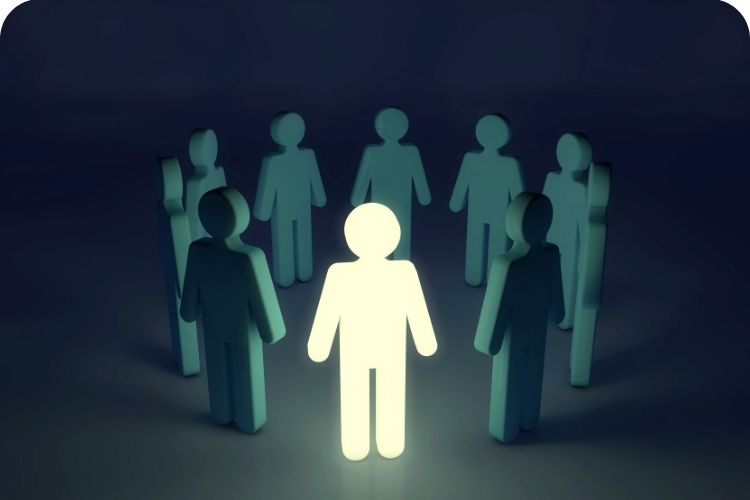 Circle of blue human cutouts with one human cutout growing white.