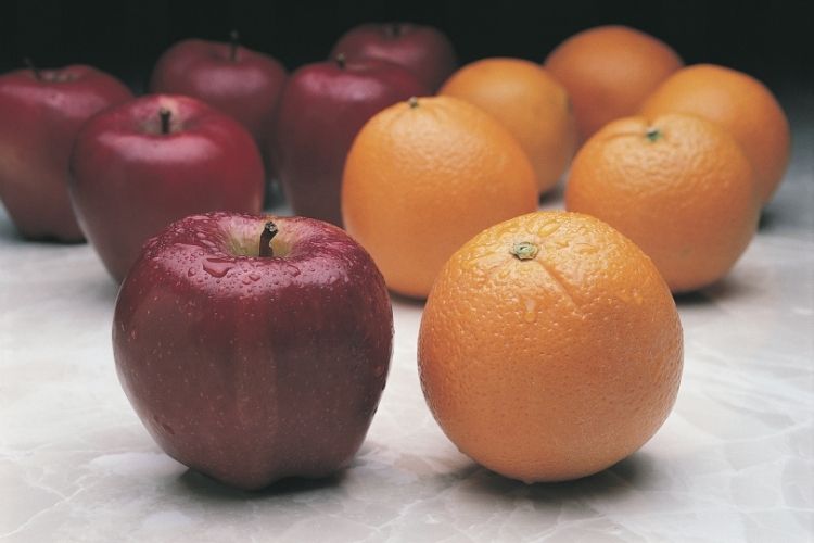 Apples and oranges sit side by side.