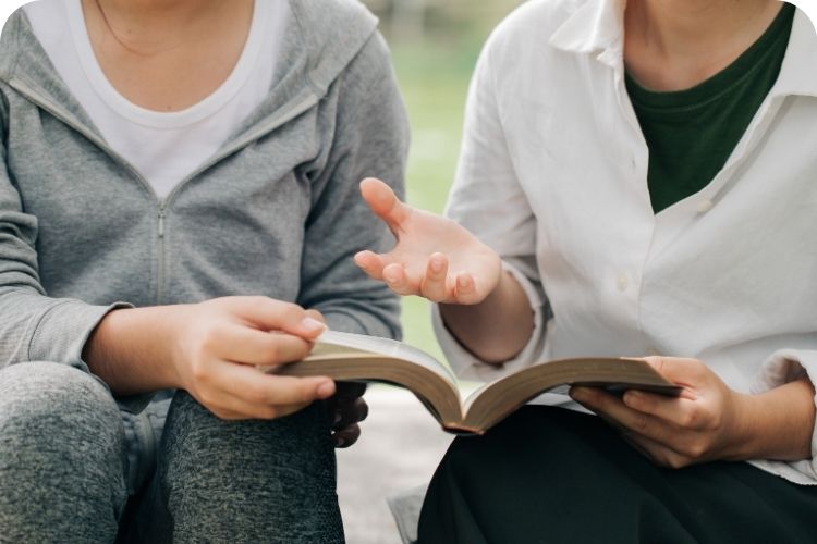 An older woman sharing the gospel with another woman.