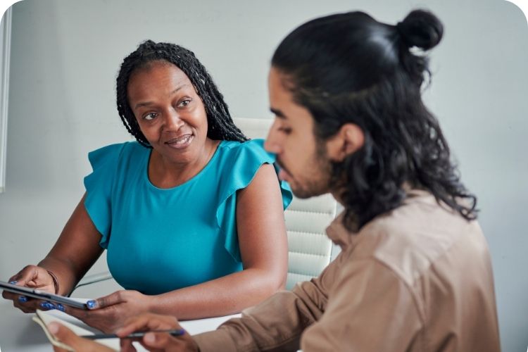A businesswoman coaching a young man.