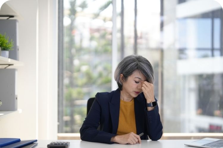A stressed businesswoman sitting at her desk.