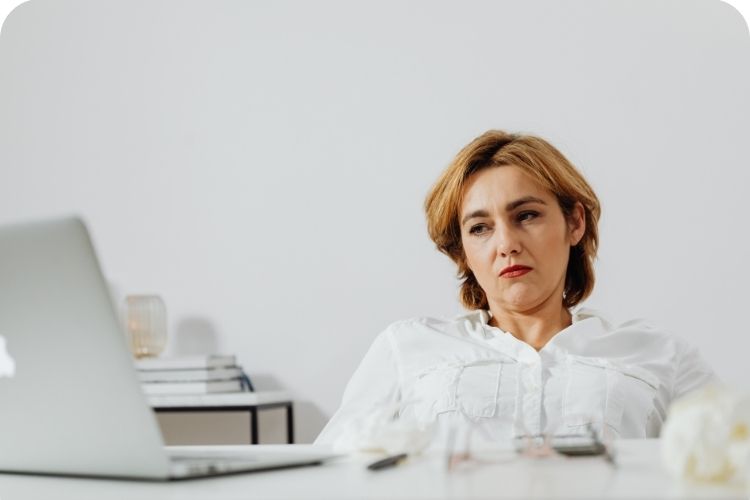 A tired woman working at her desk.