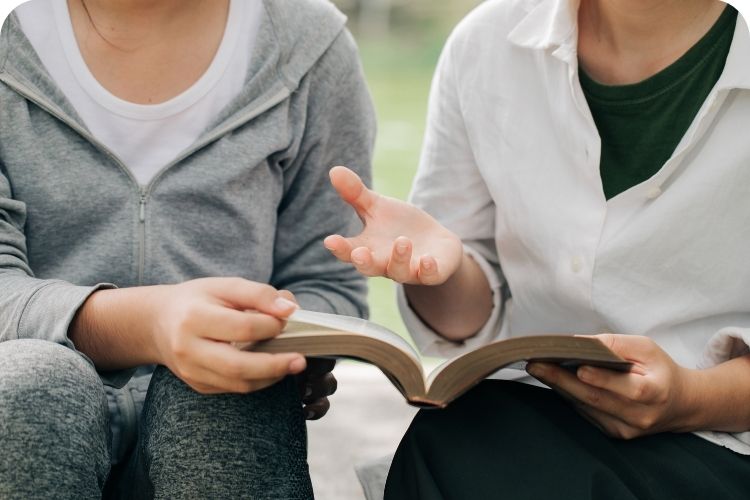 A woman teaching a Bible lesson to another woman.