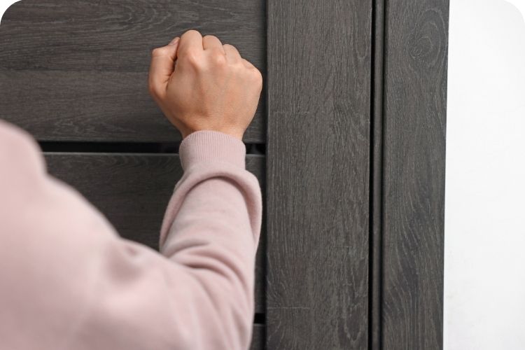 A man knocking on a front door.