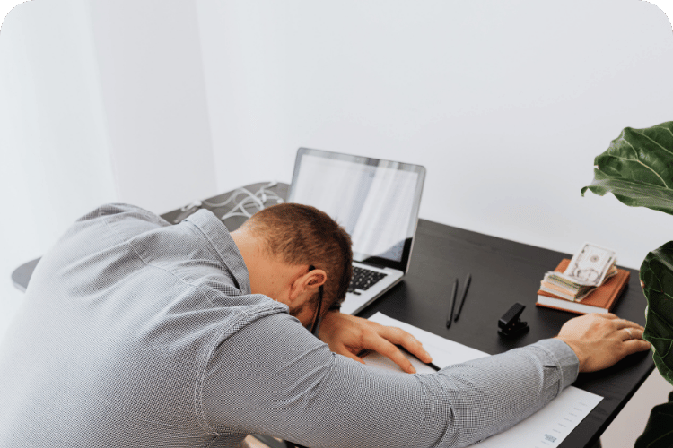 A man at his desk feeling defeated.