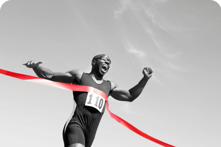 A man breaking through the ribbon at the end of a race.