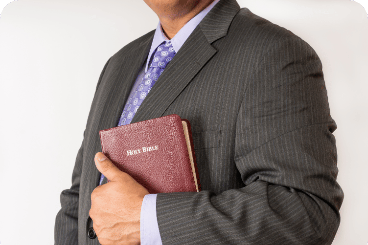 A pastor holding a Bible to his chest.