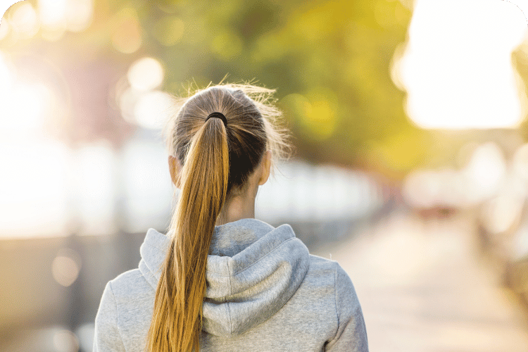 A woman walking on a sidewalk.